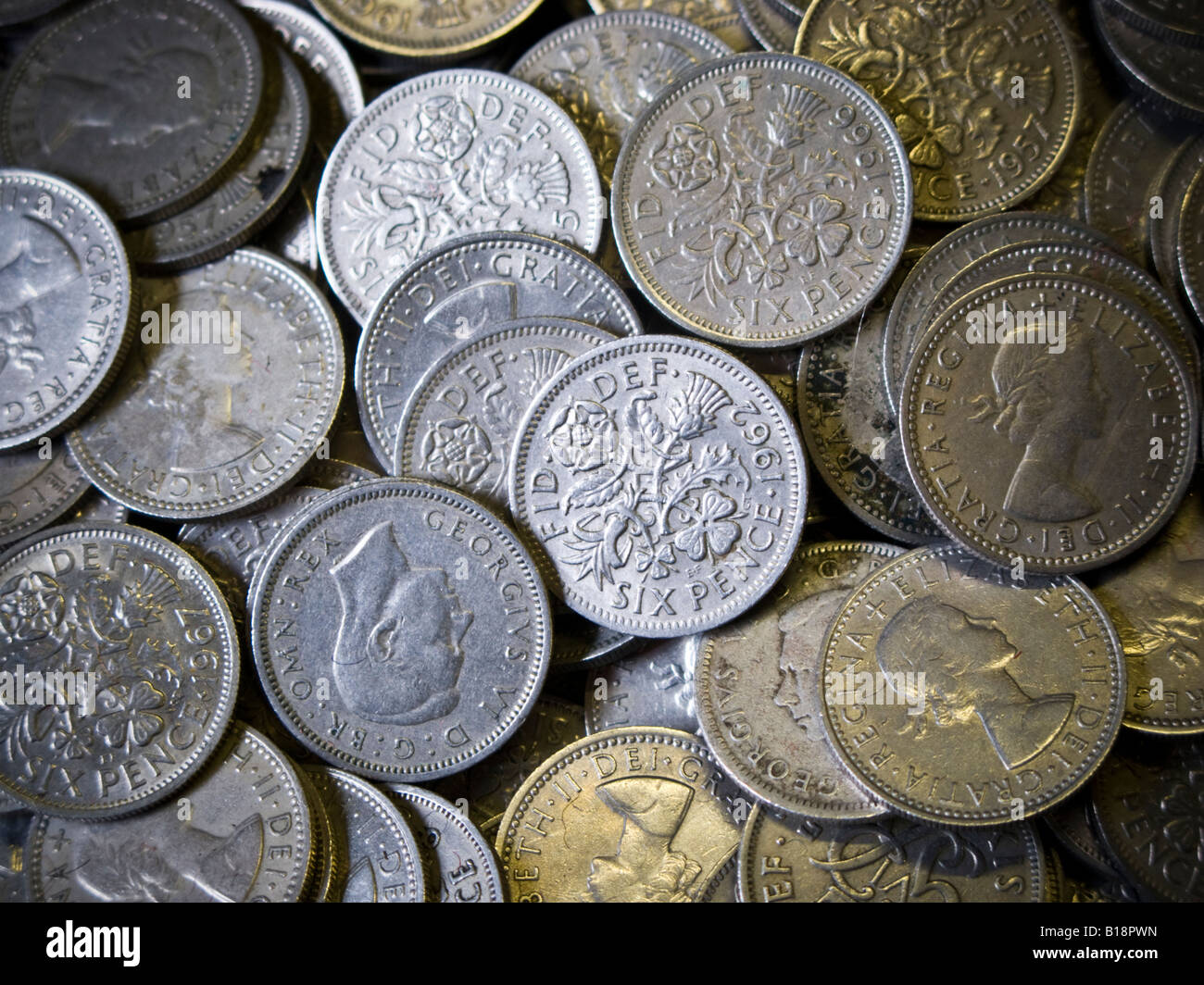 Una pila di vecchi British 'Silver' sixpenny pezzi pre era decimale 6d o un tanner o mezzo scellino vale la pena di 2,5 pence nella nuova moneta Foto Stock