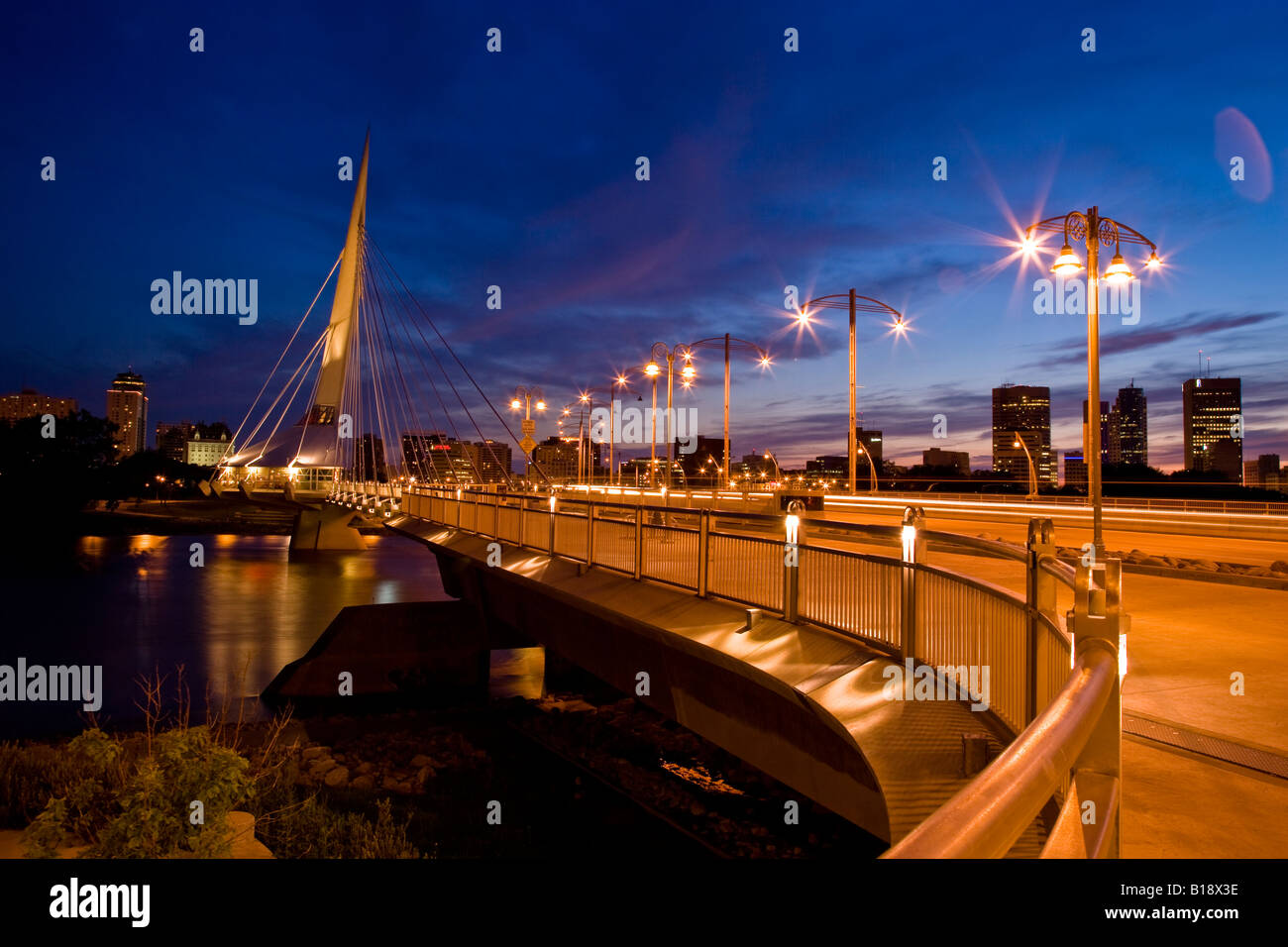 Winnipeg skyline con Esplanade Riel e Provencher ponte (oltre Red River) di notte, Winnipeg, Manitoba, Canada Foto Stock