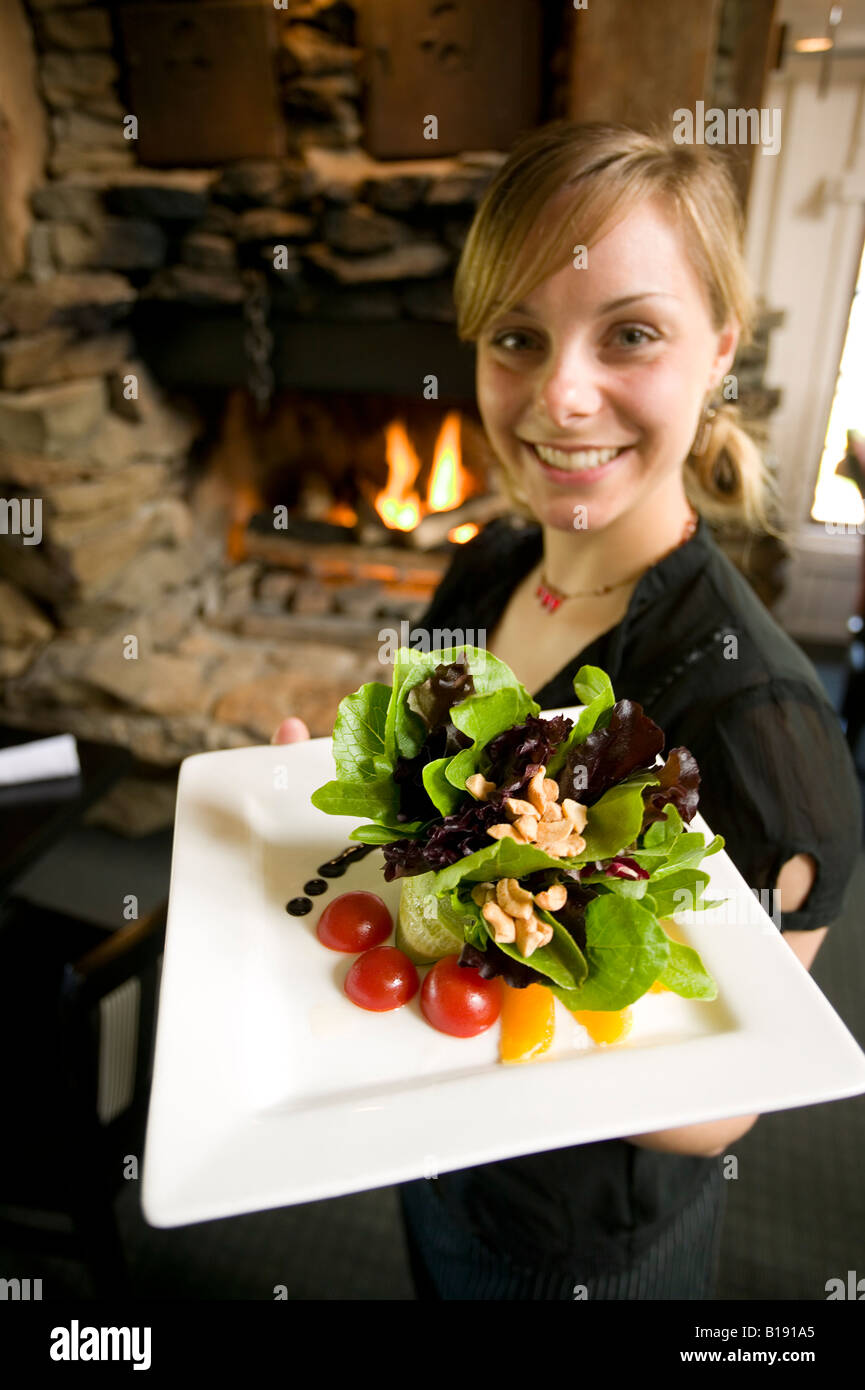Server femmina al pomodoro Pomodoro,ristorante, visualizza fresca insalata di anacardi, Courtenay, Isola di Vancouver, British Columbia, Canada. Foto Stock
