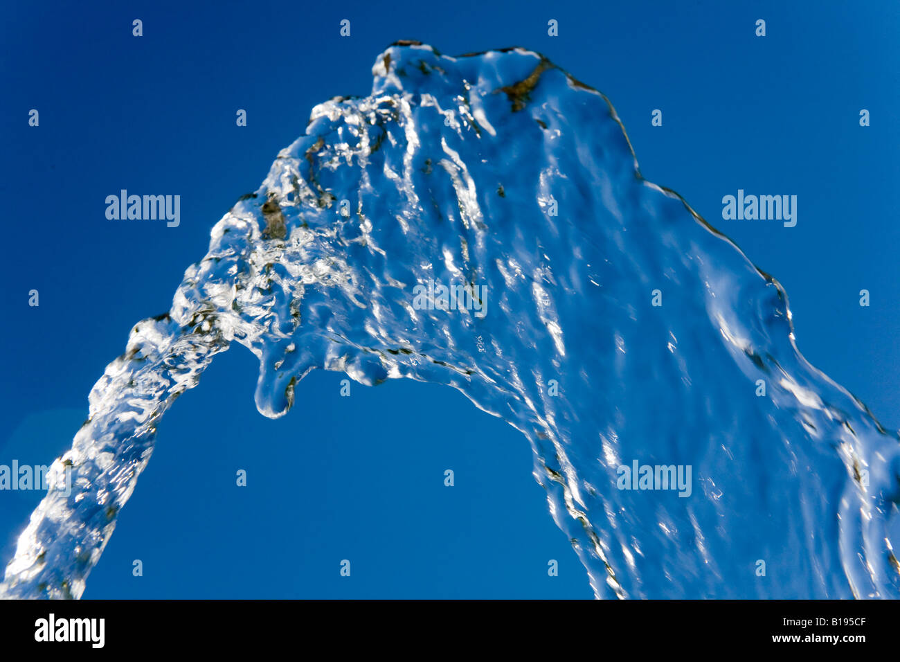 Getto di acqua congelata contro un cielo blu Foto Stock