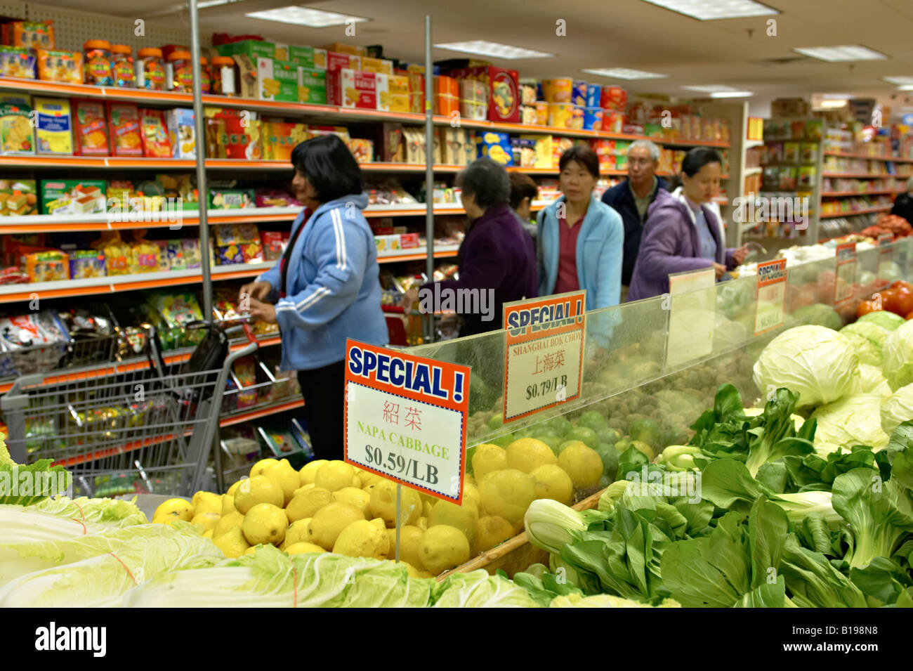 Boston Massachusetts Chinatown donne shop nella parte interna del negozio di alimentari di cibi asiatici e produrre Napa cavolo e verdure Foto Stock