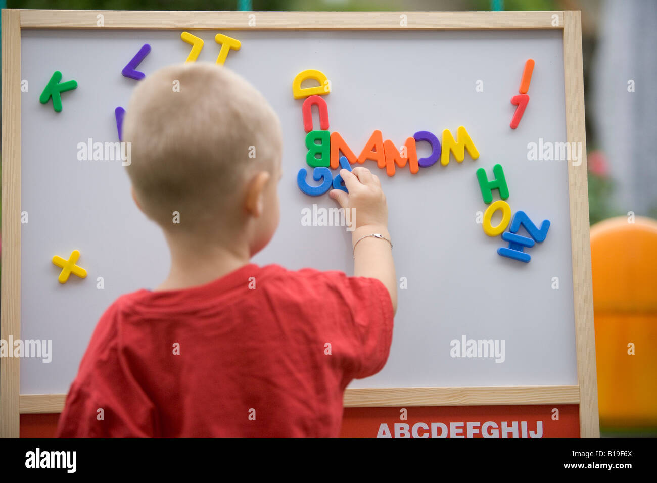 Blonde toddler giocando con le lettere Foto Stock