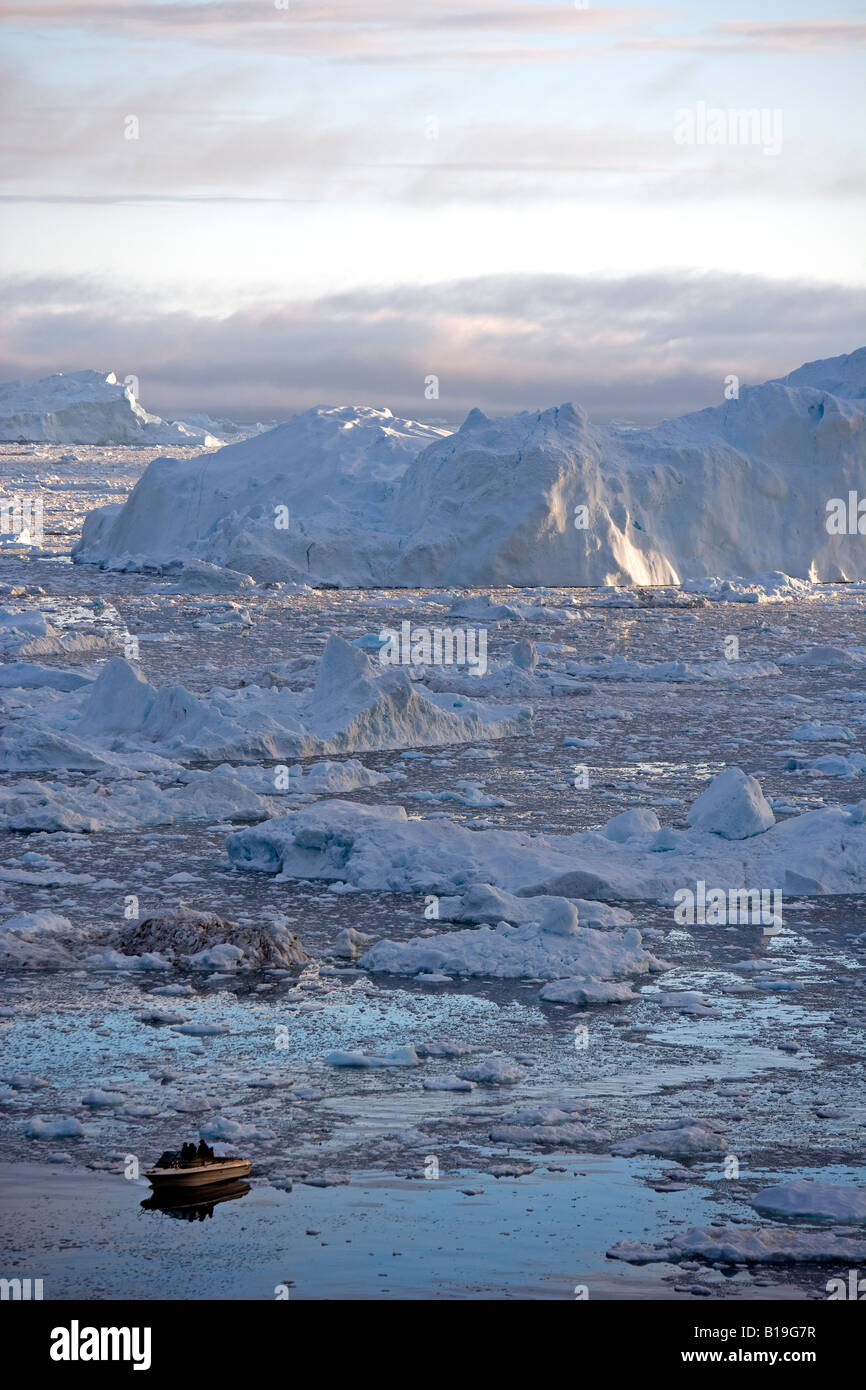 La Groenlandia, Ilulissat, Sito Patrimonio Mondiale dell'UNESCO icebergs. Una barca che naviga il suo modo attraverso il sparse iceberg. Foto Stock