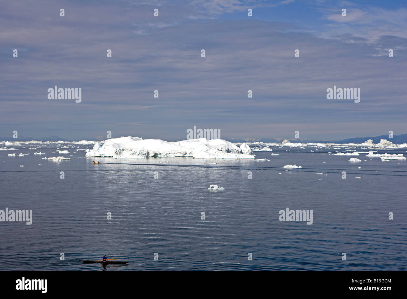 La Groenlandia, Ilulissat, Sito Patrimonio Mondiale dell'UNESCO icebergs. Utilizzando un kayak di tradizionale design Inuit, un avventuriero pagaie da. Foto Stock