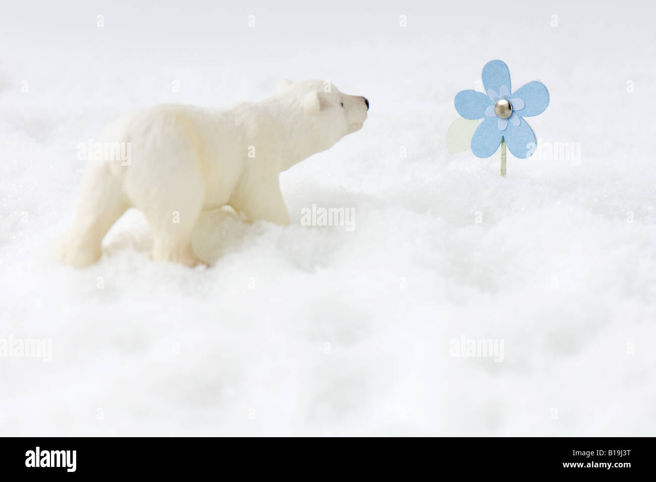 Toy orso polare nella neve, guardando il Fiore artificiale Foto Stock