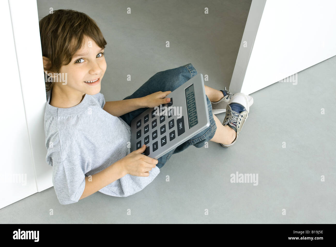 Boy utilizzando la calcolatrice di grandi dimensioni Foto Stock
