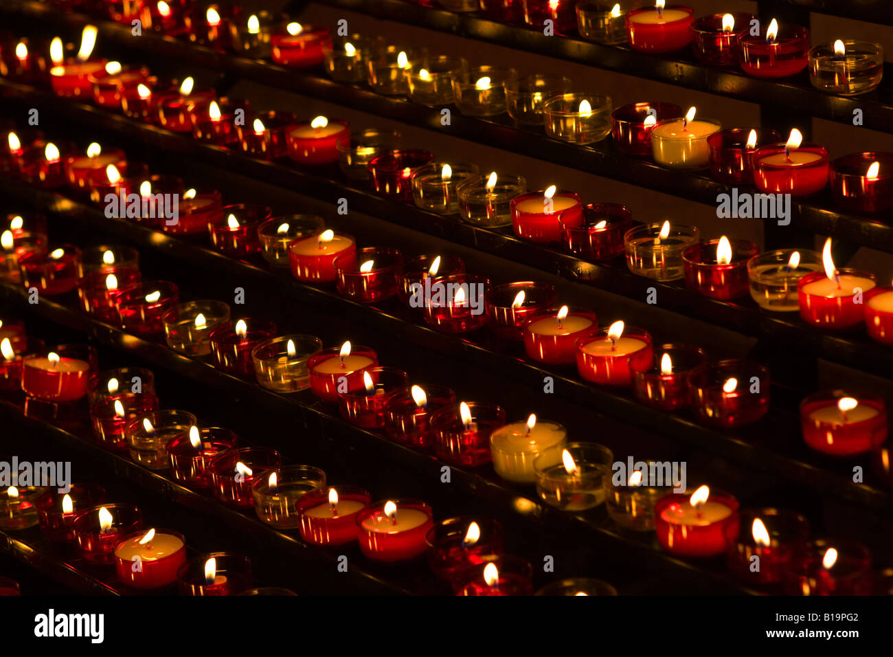 Fila di piccole candele accese come offerte in una chiesa di Notre Dame de la Garde, Marsiglia, Francia, Europa Foto Stock