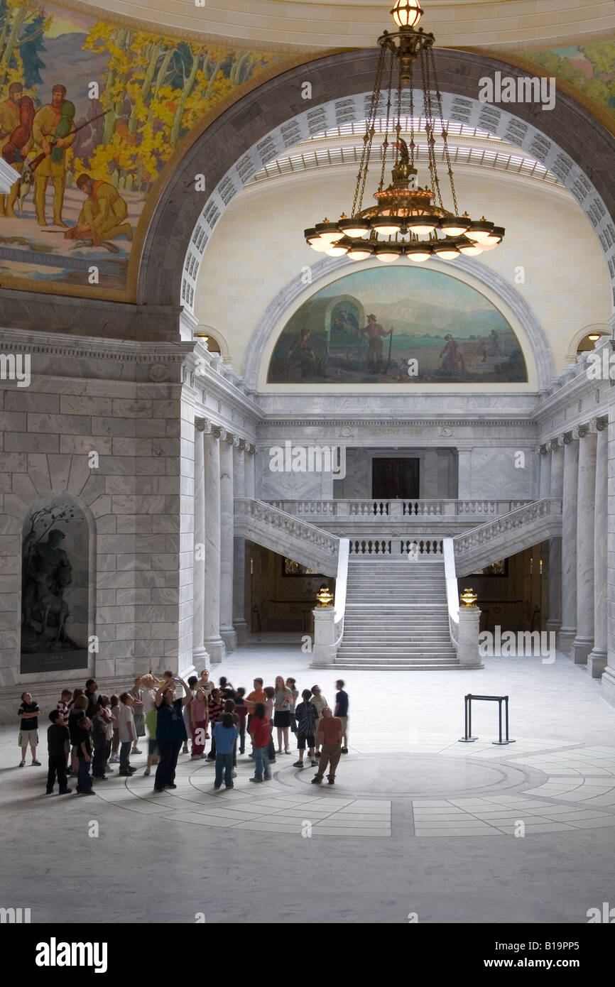 Un gruppo di bambini in età scolare su un tour della Utah State Capitol Building in Salt Lake City cercando fino alla rotonda e murali Foto Stock