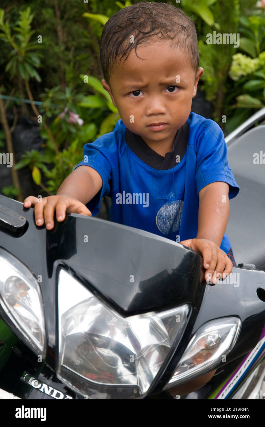 Indonesia Bali isola lago Bratan Candikuning ritratto di un giovane ragazzo in sella a una motocicletta Foto Stock