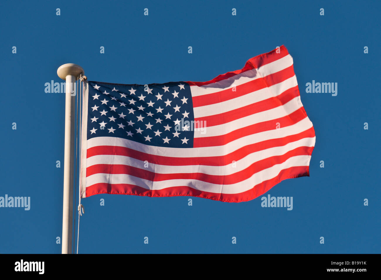 Bandiera americana al vento su un cielo blu sullo sfondo. Foto Stock