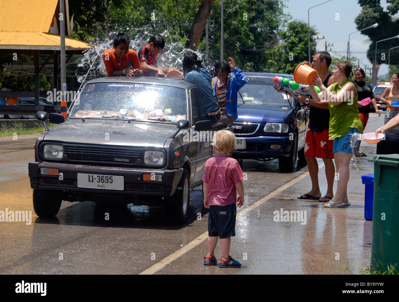 Western bambino (Wilf) guardando waterfight per Songkran festival di Kao Lak, Thailandia Foto Stock