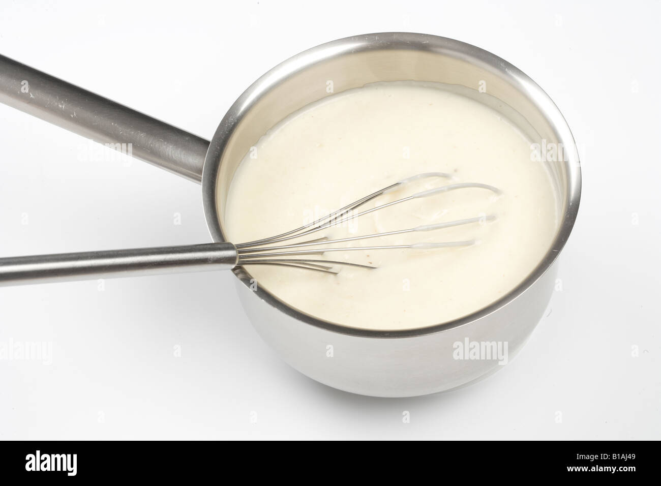 Preparare la farina e il latte per fare la besciamella Foto Stock