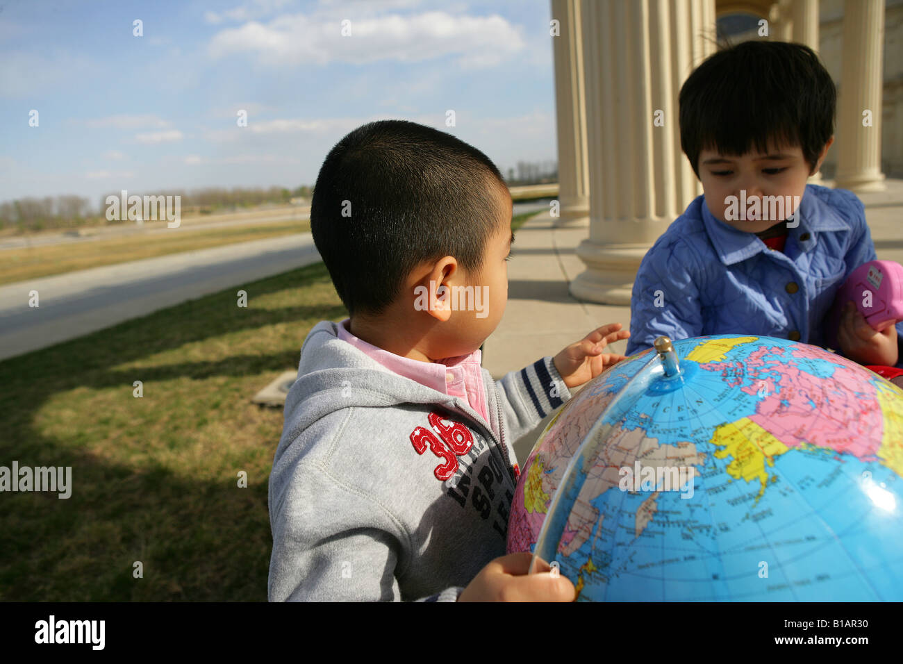 Due bambini alla ricerca di una sfera globale Foto Stock