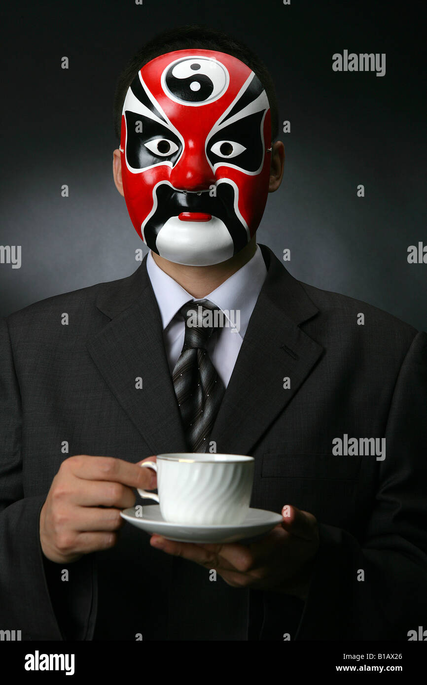 Businessman cinesi che indossa una maschera di opera Foto Stock