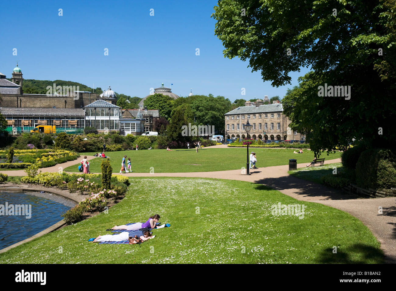 Ragazze rilassante al sole, il Pavilion Gardens, Buxton, Peak District, Derbyshire Inghilterra Foto Stock