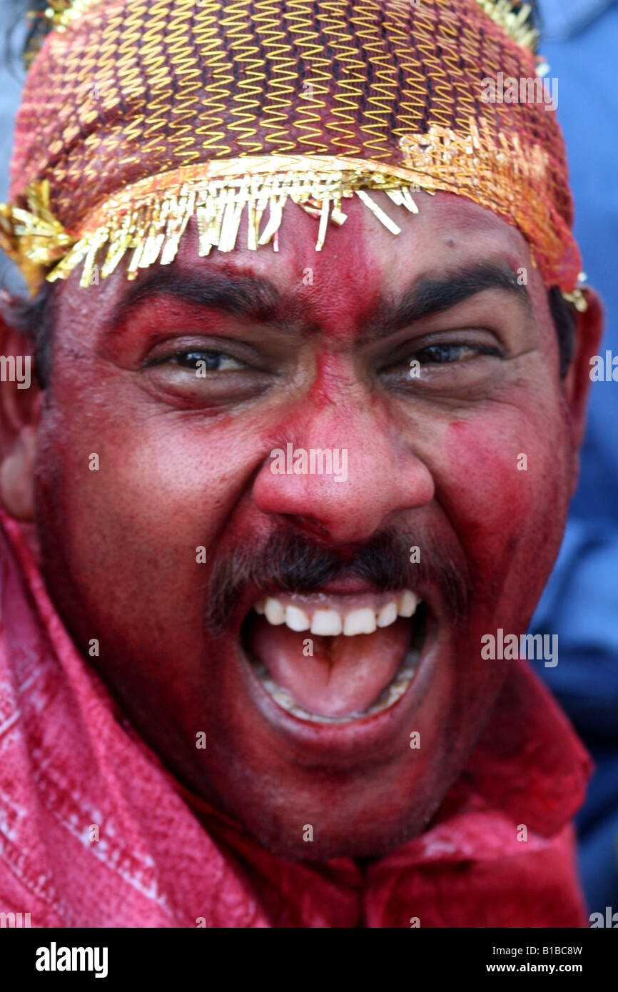 Uomo bengalese con rosso vermiglio sul suo volto che celebra l'immersione di un Durga idolo per Dasara , India Foto Stock