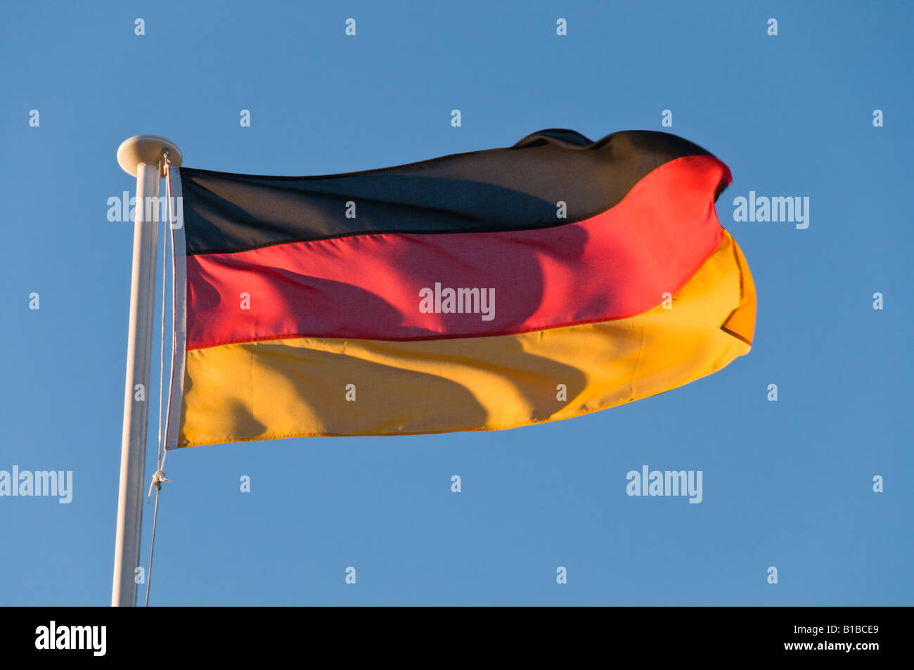 Una bandiera tedesca al vento su un cielo blu sullo sfondo Foto Stock