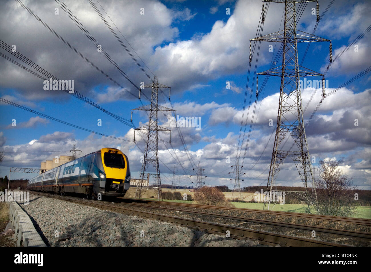 Un East Midlands meridiano treni treno passa nelle torri di raffreddamento e tralicci a E.ON Ratcliffe su Soar power station Foto Stock