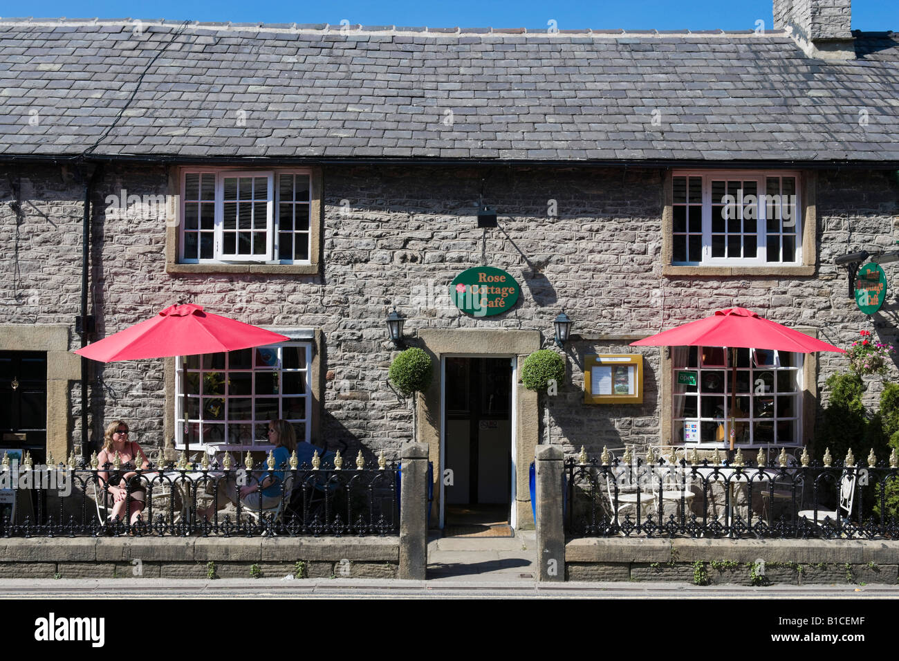 Due Woment seduto fuori il Rose Cottage Cafe, Castleton, Peak District, Derbyshire, England, Regno Unito Foto Stock
