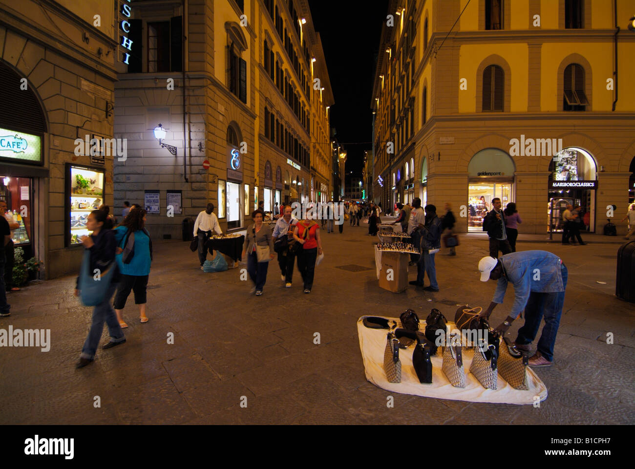 Venditori ambulanti di vendita falsi borsette nel centro di Firenze di notte Italia EU Europe Firenze Foto Stock