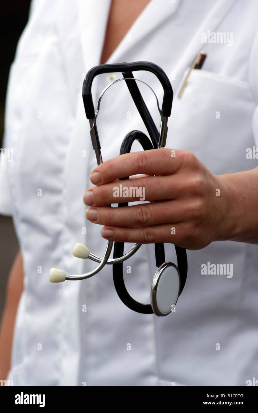 Uno stetoscopio in mano di un bianco rivestito medico curante Foto Stock