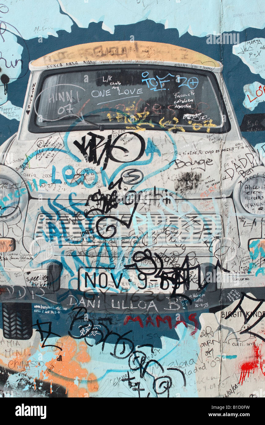 Berlino Germania sezione del muro di Berlino presso la Galleria Eastside mostra tedesco orientale Trabant vettura graffiti di arte murale Foto Stock
