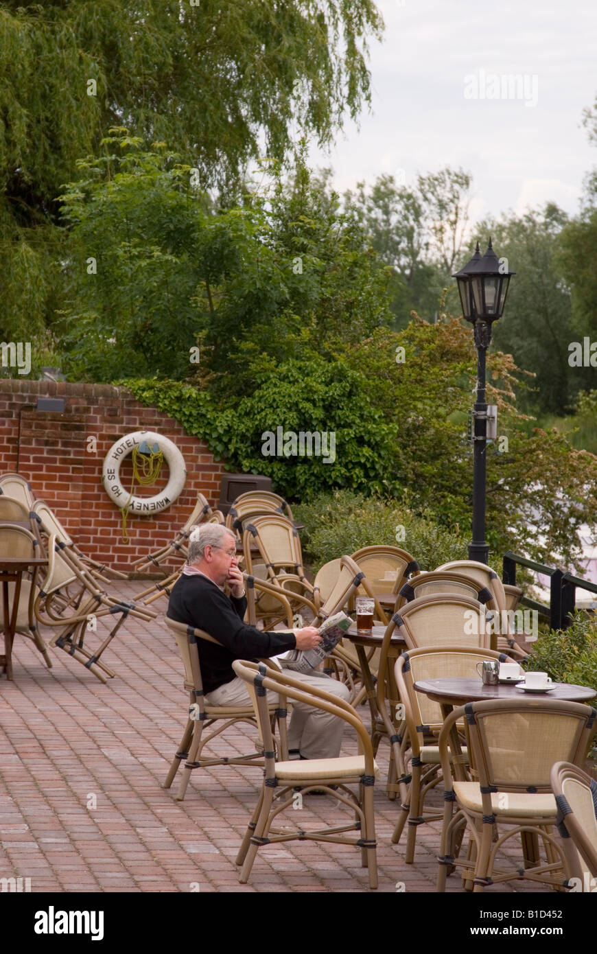 Uomo che legge il giornale e avente un drink presso l'Hotel Waveney,Beccles,Suffolk, Regno Unito Foto Stock