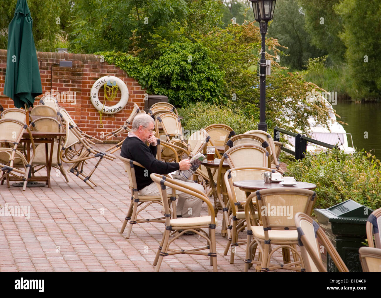 Uomo che legge il giornale e avente un drink presso l'Hotel Waveney,Beccles,Suffolk, Regno Unito Foto Stock