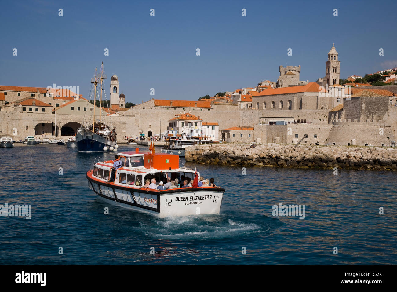 Cunard QE2 nave enterring gara porto di Dubrovnik con nave a vela lasciando astrale Foto Stock