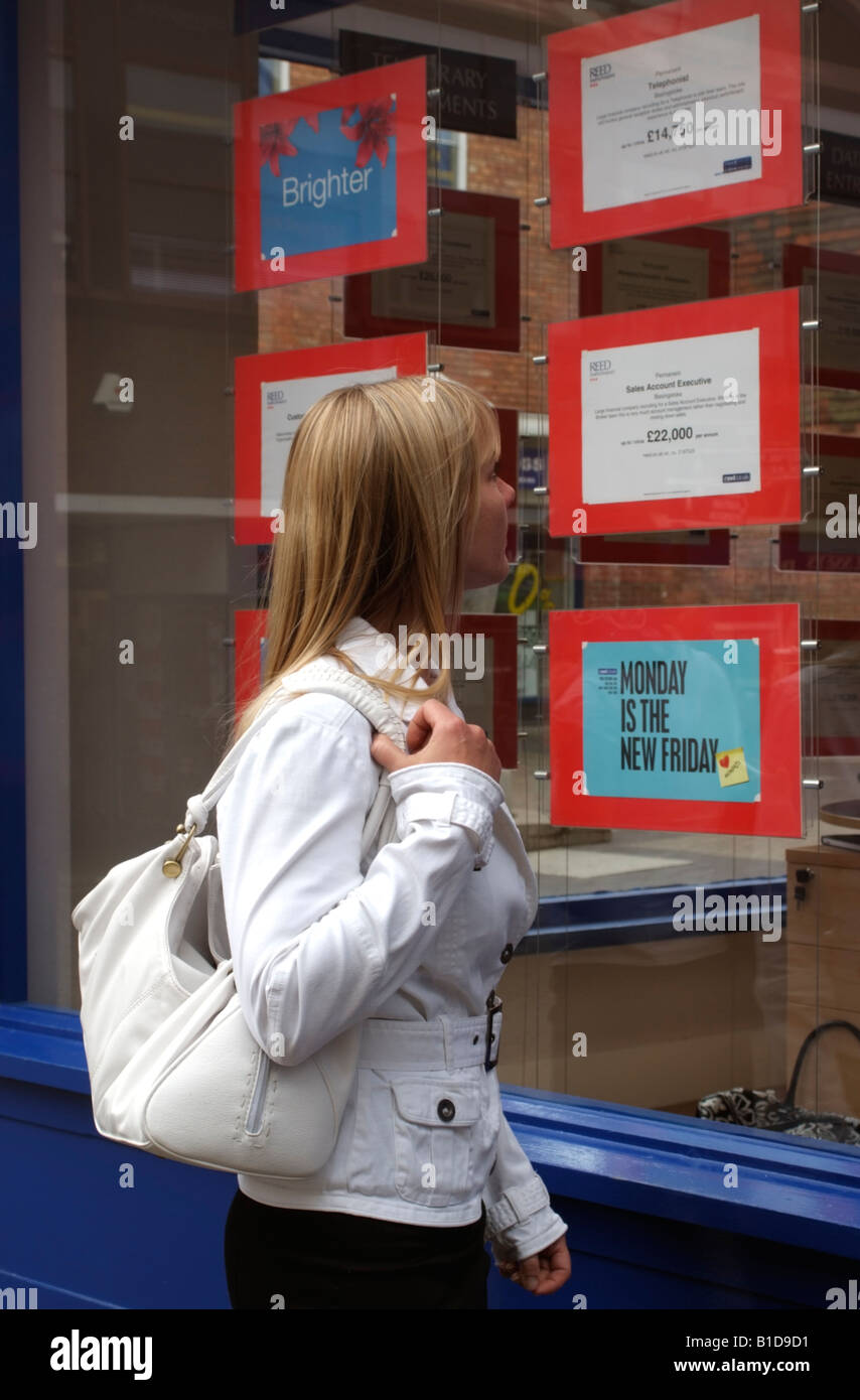 Donna in cerca di un lavoro o di cambiamento di carriera Posti vacanti pubblicizzato nella finestra di agenzia di reclutamento locali la ricerca di lavoro Foto Stock