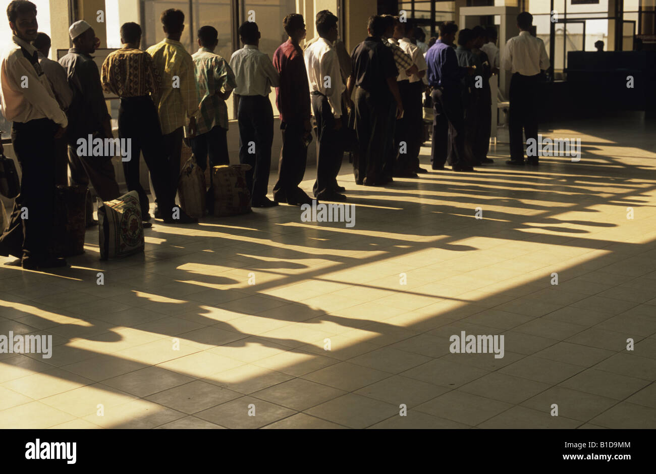 I lavoratori migranti vincolati per il golfo di attendere per passare attraverso il controllo di sicurezza prima di iniziare il loro volo Foto Stock