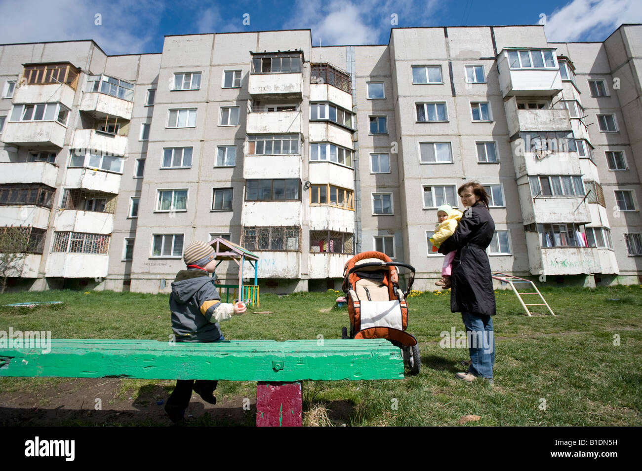 Madre e bambini al di fuori nella parte anteriore del calcestruzzo era sovietica blocchi di appartamenti in Yuzhno Sakhalinsk Isola Sakhalin in Russia 2008 Foto Stock