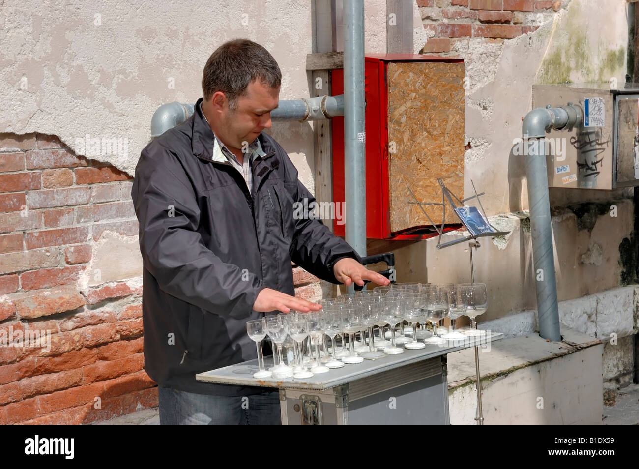 Musicista di riproduzione di musica con bicchieri di vino, Venezia, Veneto, Italia Foto Stock