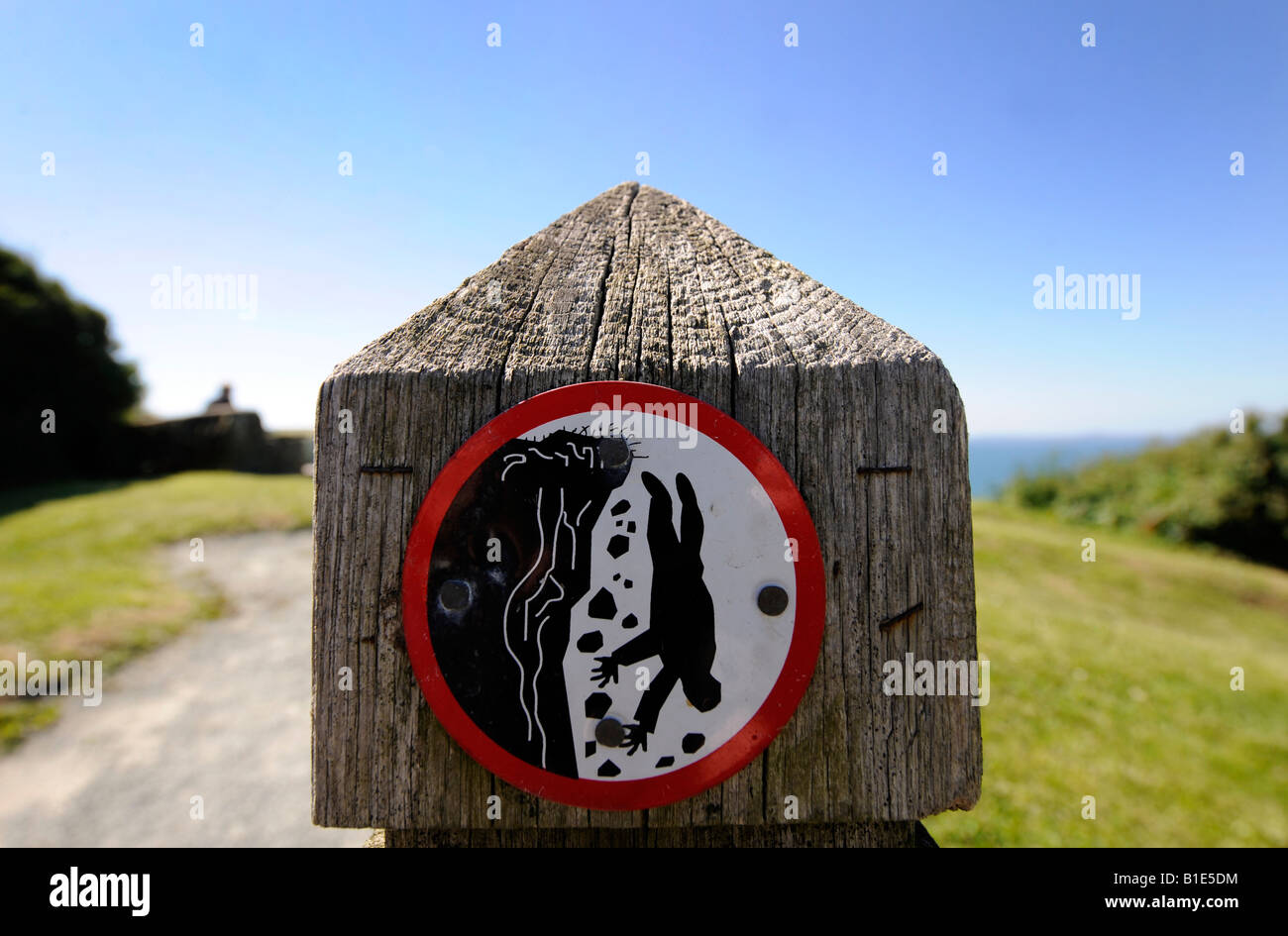 Una scogliera cadere un cartello di segnalazione sull A COASTAL CLIFFTOP percorso sulla costa gallese.UK. Foto Stock
