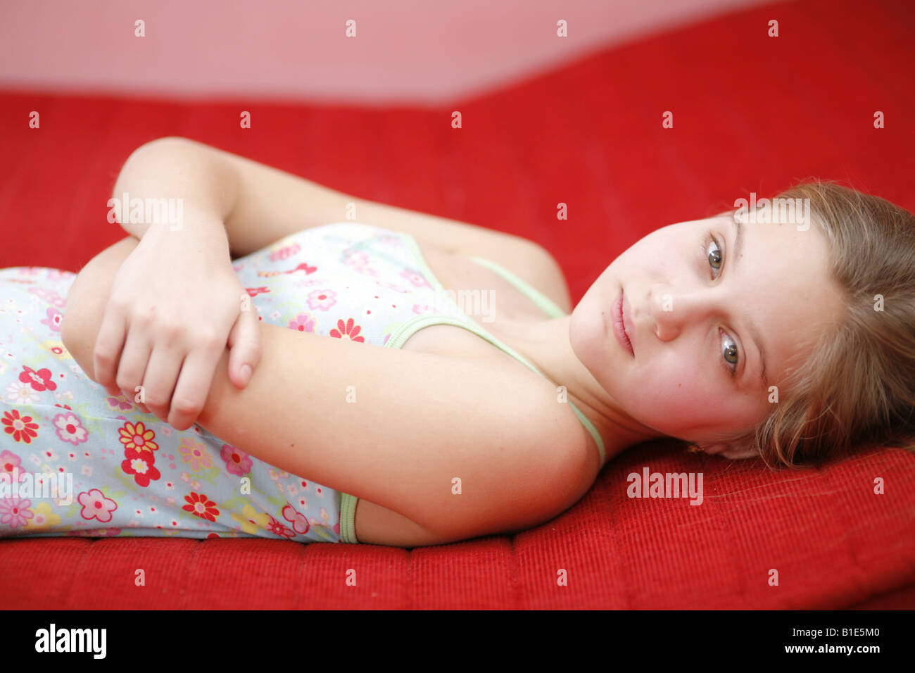Triste ragazza preteen posa sul letto Foto Stock