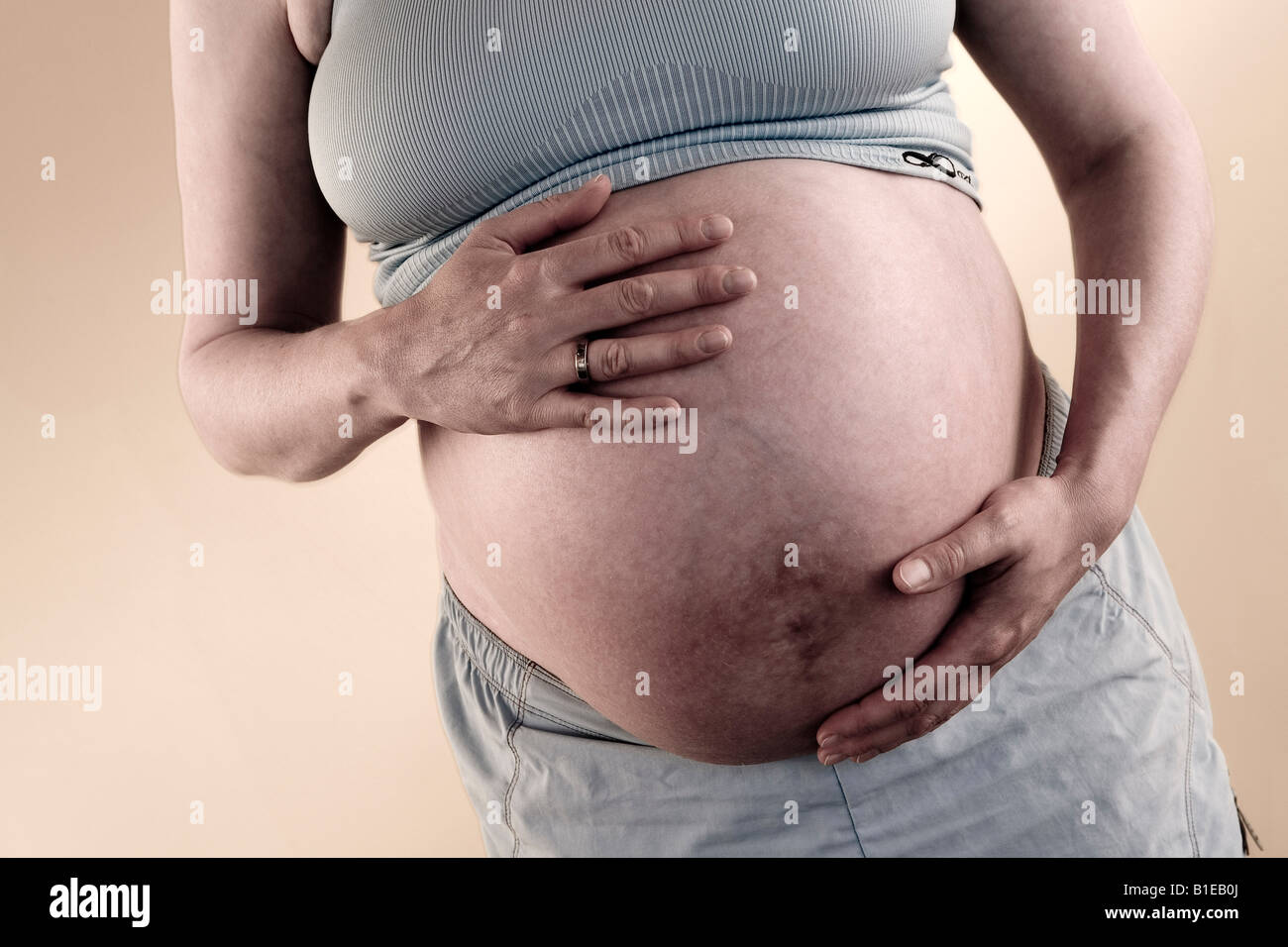 Vista frontale della donna incinta lo stomaco mentre indossa halter top e shorts Alaska Stati Uniti Foto Stock