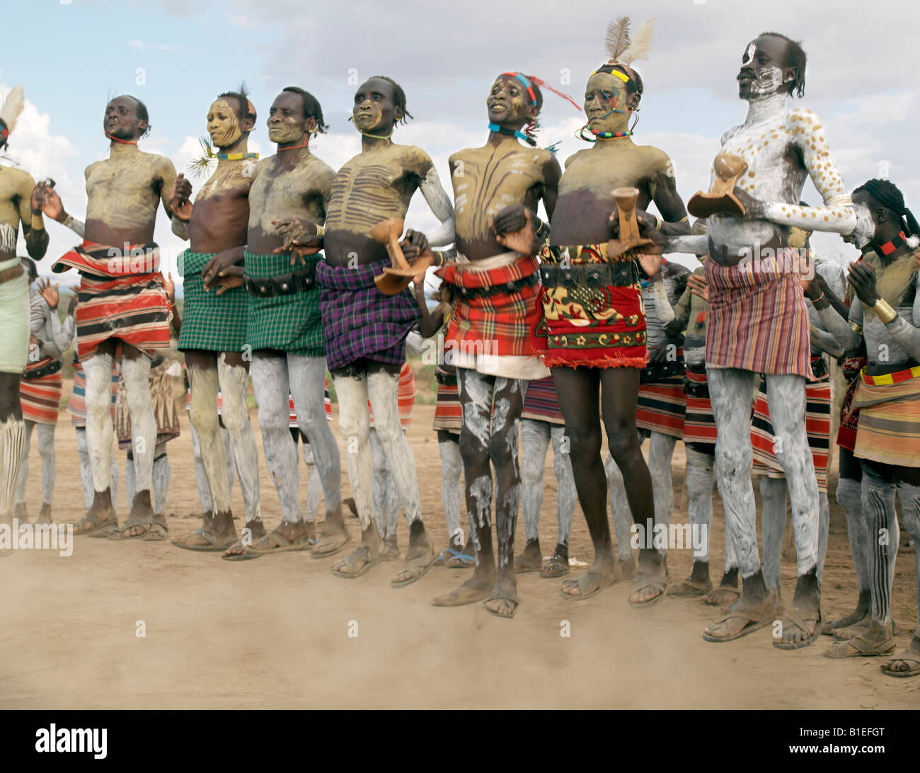 Karo Men dance in linea da saltare in aria in alto, gambe dritte. Anche mentre balli, ognuno di essi conservare loro Sgabelli in legno Foto Stock