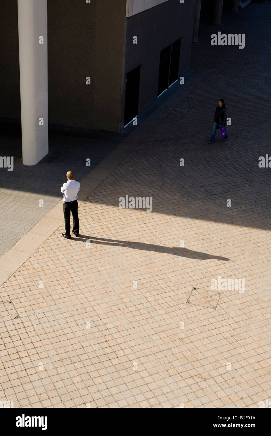 Un lavoratore di ufficio in piedi sotto il sole, London, Regno Unito Foto Stock