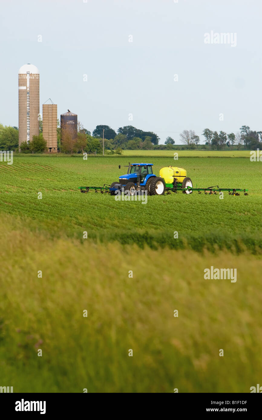 Un trattore lo spandimento di fertilizzante su una tarda primavera del settore rurale in Illinois. Foto Stock