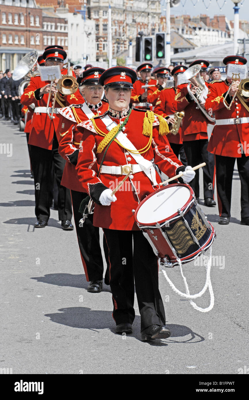 I percussionisti dell'esercito britannico in rosso cerimoniali tuniche marzo attraverso le strade di Weymouth a un Welcome Home Parade Foto Stock