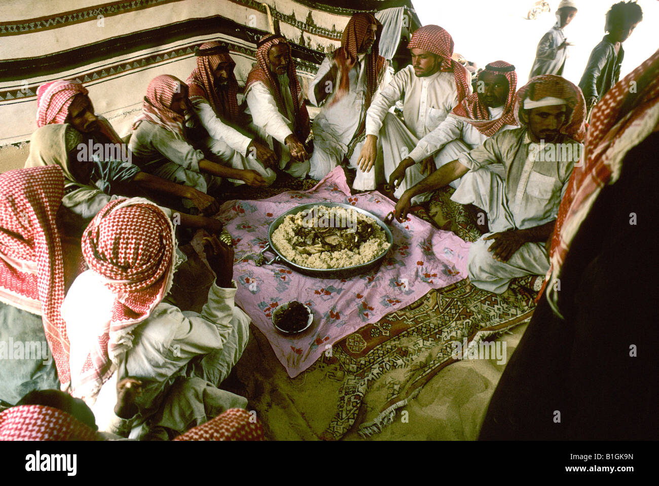 Arabia Saudita Empty Quarter. Al Murrah beduino attendere il segnale di start per scavare il cammello carne e riso Foto Stock