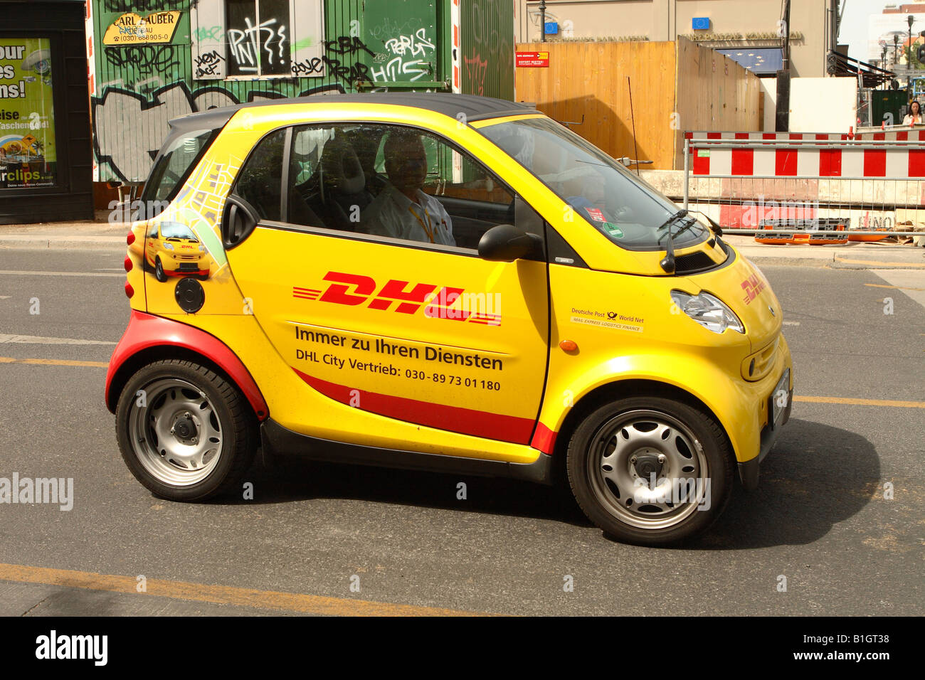 DHL Smart Car international parcel pacchetto mail corriere consegna veicolo fermo a Berlino Germania Foto Stock