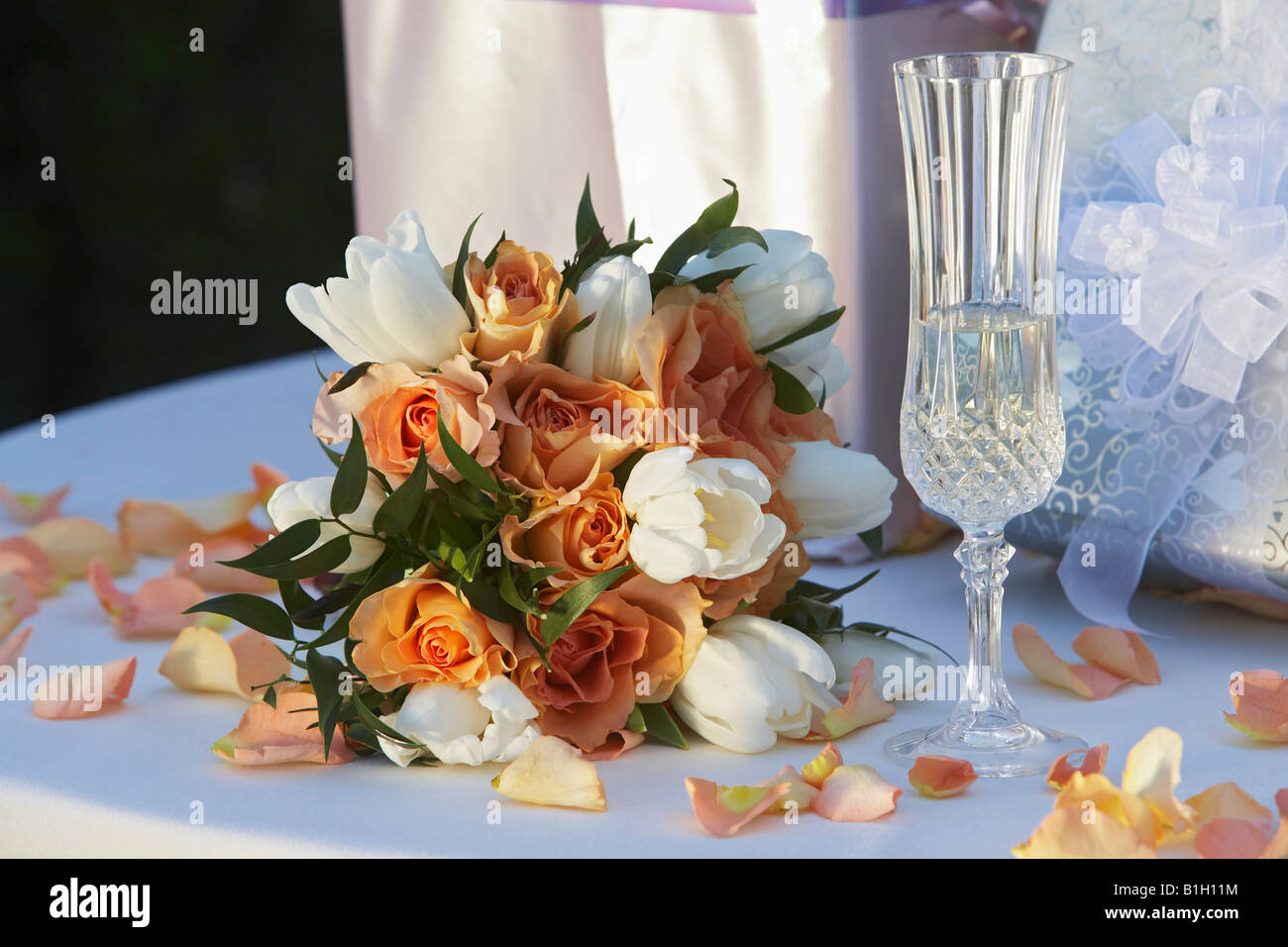 Bouquet, bicchiere di champagne e presenta sulla tavola, close-up Foto Stock