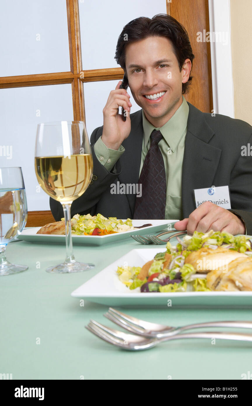 Metà adulto uomo d affari parlando su mobile al ristorante tabella Foto Stock