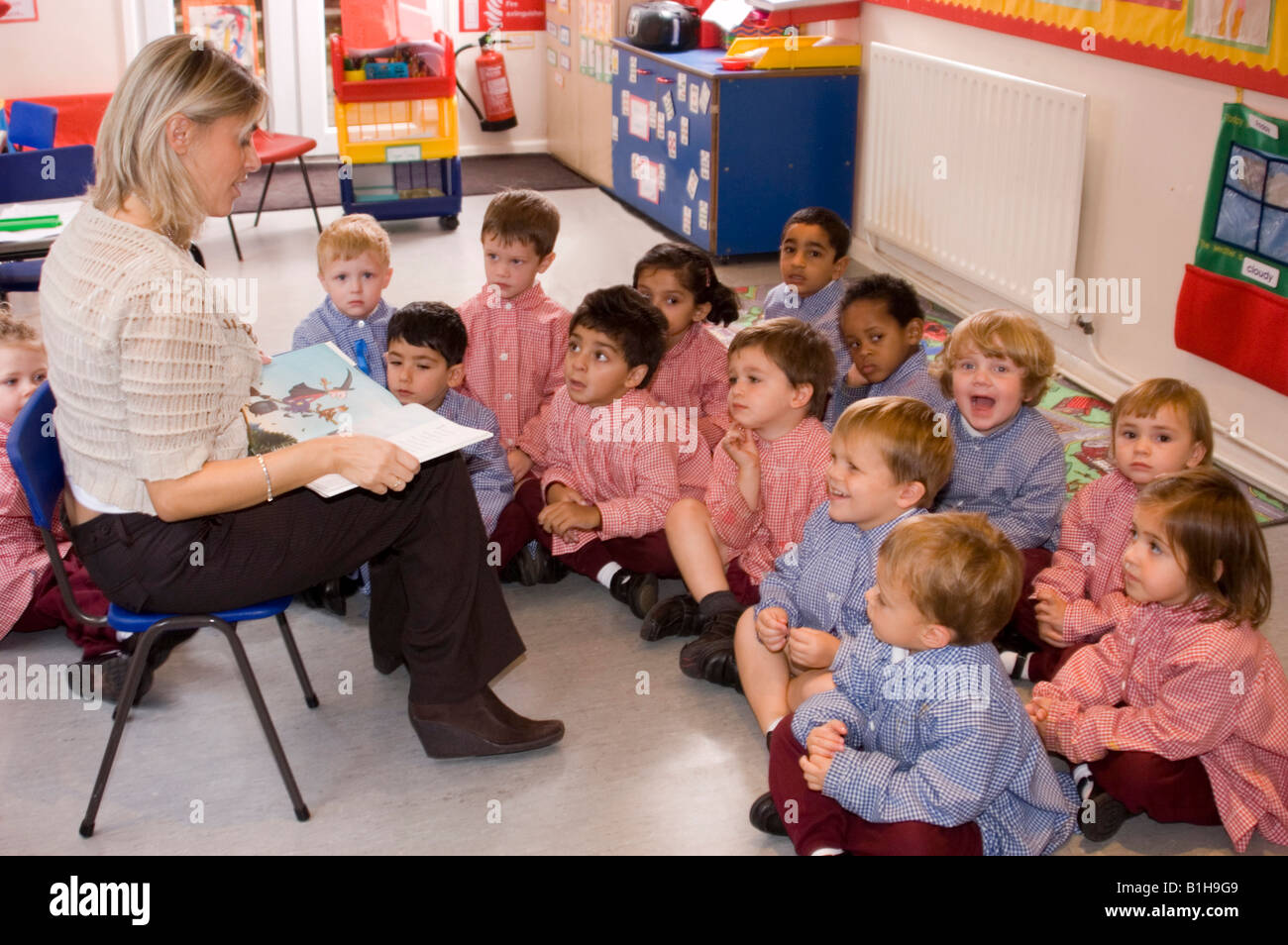 Insegnante la lettura per bambini della scuola materna Foto Stock