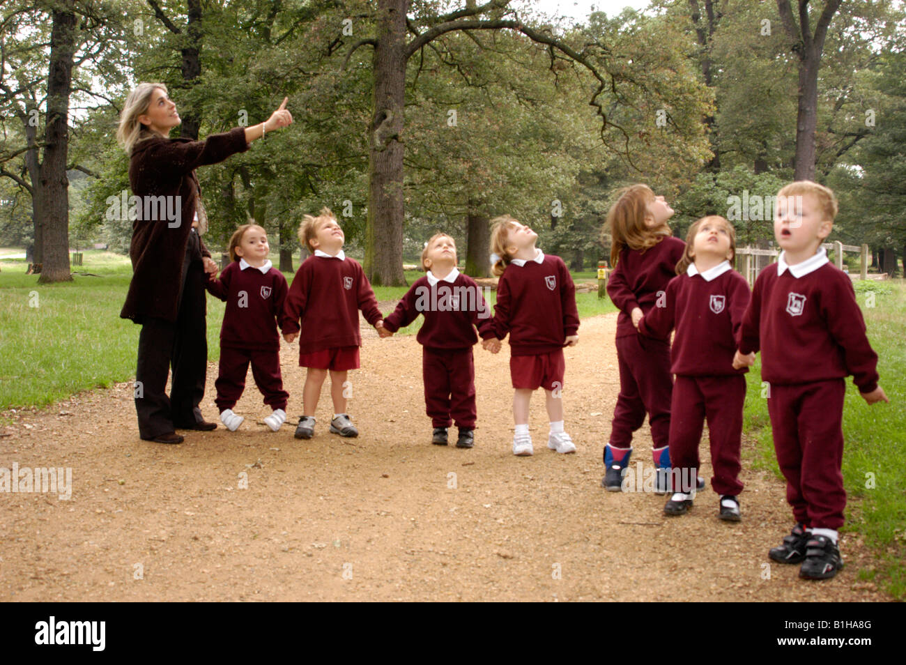 Insegnante con i bambini della scuola elementare nel parco a studiare la natura Foto Stock