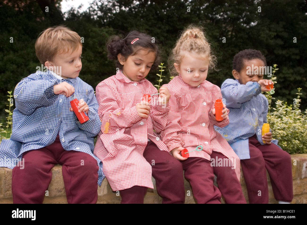 I bambini presso un privato scuola infantile giocando con bolle Foto Stock