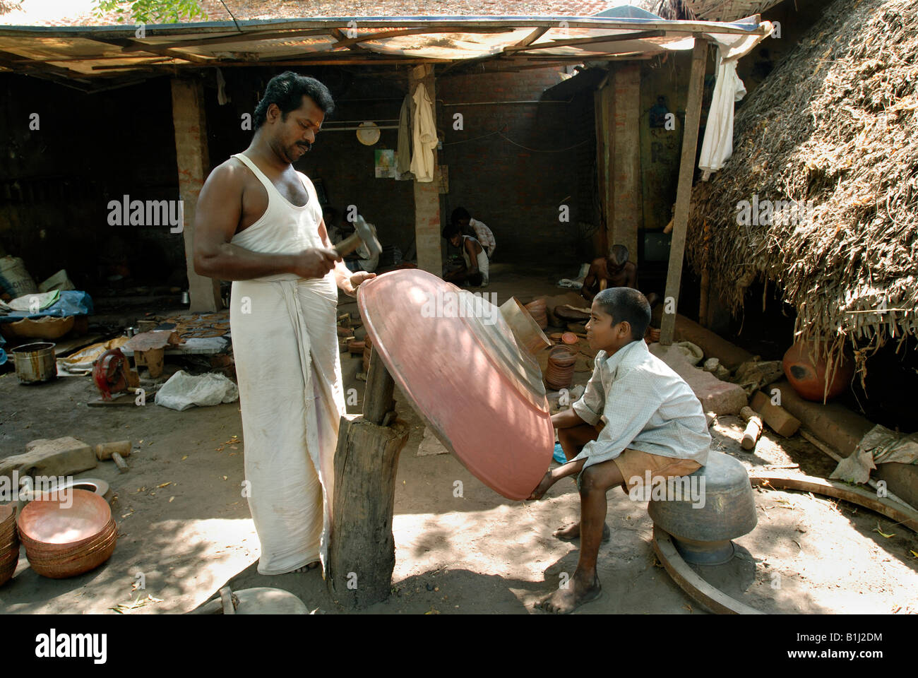 Metà uomo adulto e suo figlio facendo un gopura kalasam, Darasuram, Thanjavur distretto, Tamil Nadu, India Foto Stock