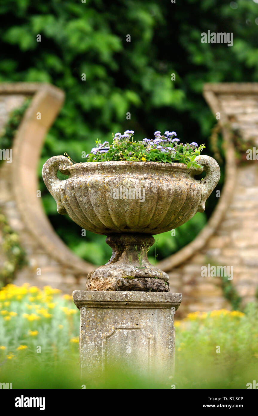 Un antico urna di pietra in un giardino murato con una forma a ferro di cavallo DESIGN FINESTRA REGNO UNITO Foto Stock