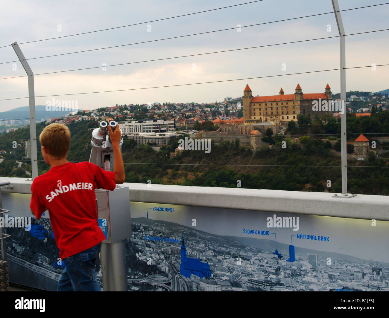 Ragazzo del telescopio su un punto panoramico con vista sulla città e il castello di Bratislava, Slovacchia, Bratislava Foto Stock